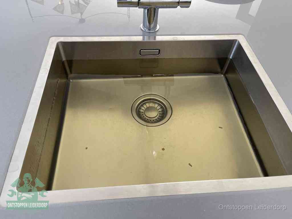 Een RVS spoelbak met stilstaand water dat niet wegloopt, een van de eerste signalen van een beginnende verstopping in Leiderdorp