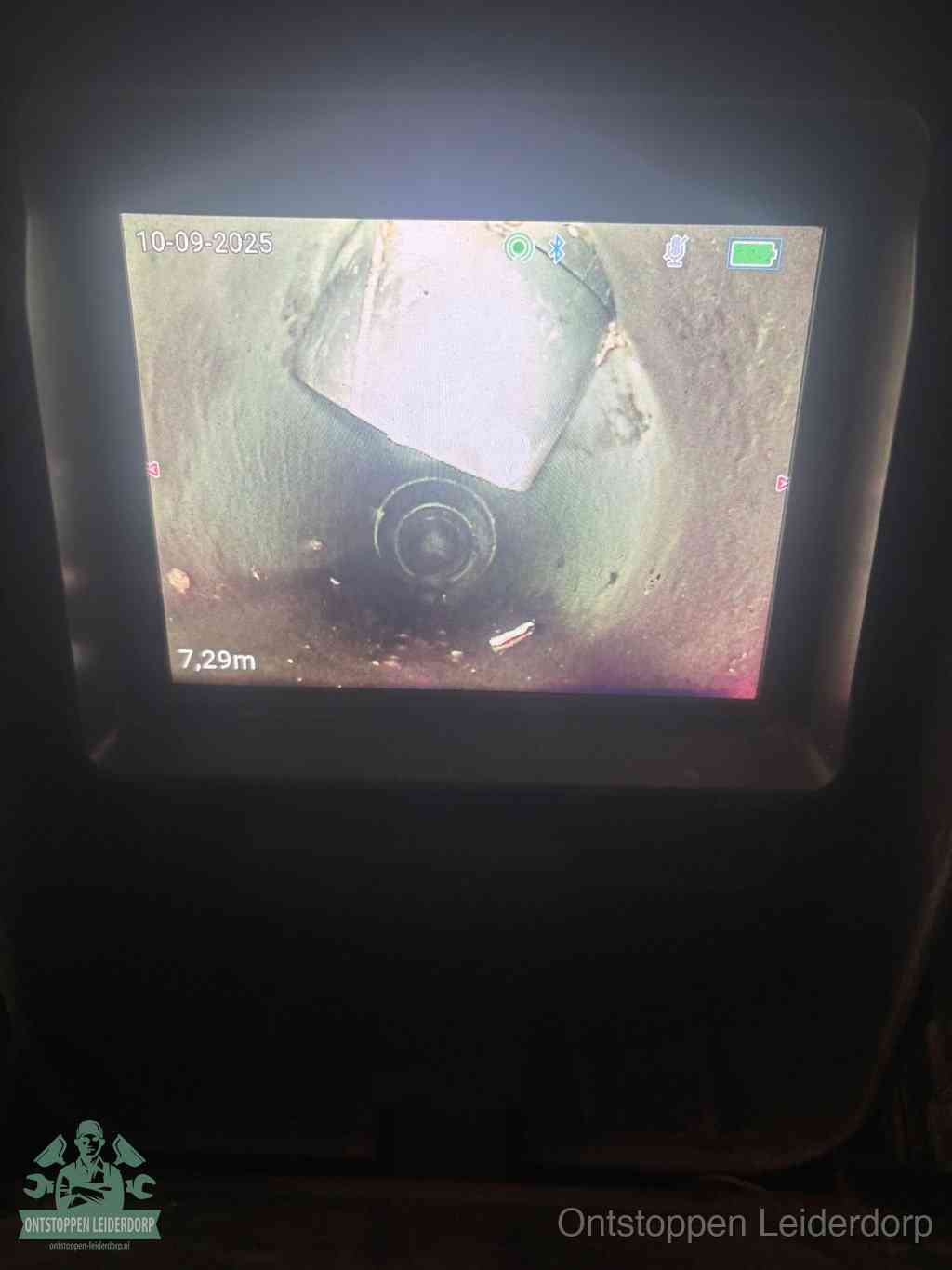 Het scherm van een rioolinspectiecamera toont de binnenkant van de leiding, eerst vaststellen waar de verstopping zit in Leiderdorp