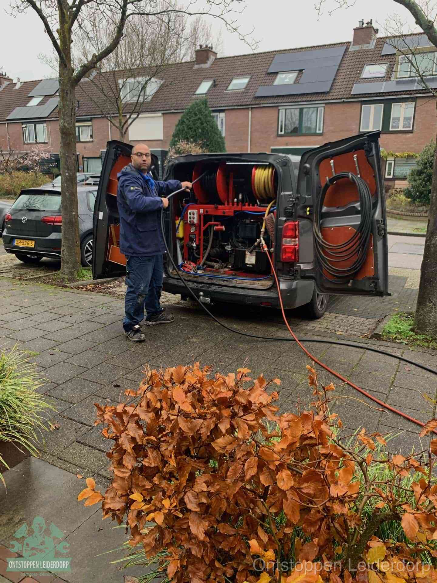 Een monteur staat bij zijn open bestelbus met hogedruk-rioolreinigingsapparatuur, klaar om binnen 30 minuten uit te rukken voor een spoedverstopping in Leiderdorp