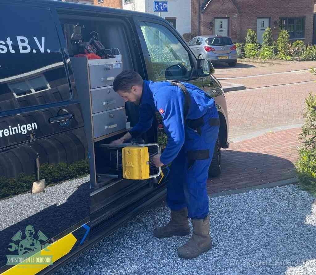 Een monteur pakt gereedschap uit de bedrijfsbus, het moment om een professionele ontstoppingsdienst in te schakelen in Leiderdorp