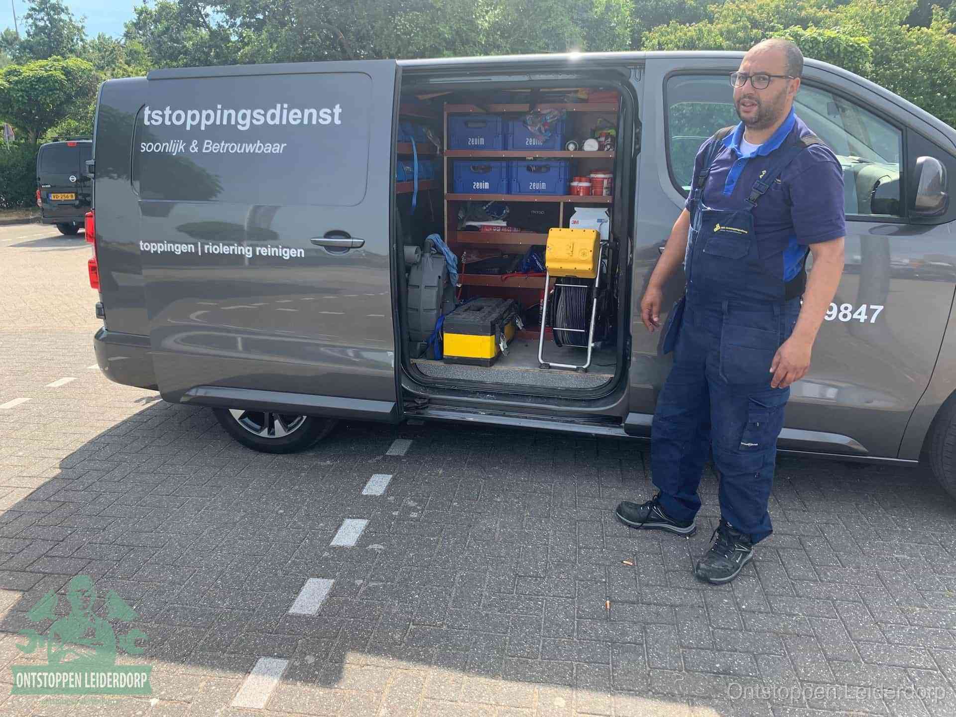 Een monteur staat klaar bij zijn bedrijfsbus met gereedschap, de vaste werkwijze van de ontstoppingsdienst in Leiderdorp